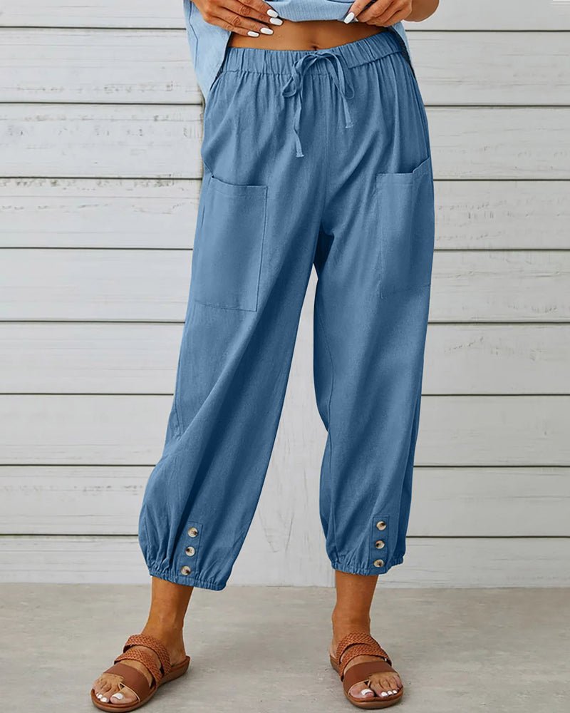 Sky blue relaxed-fit trousers with elastic waist, drawstring, side pockets, button cuff hem.