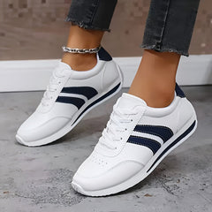 Scarpe bianche con inserti blu e lacci; suola antiscivolo e profilo laterale