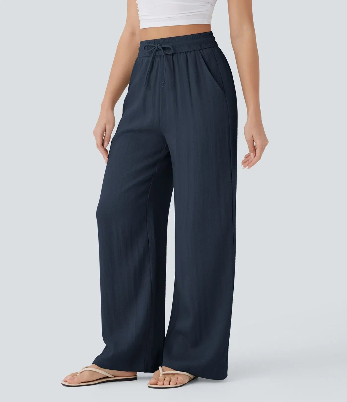 Navy blue wide-leg trousers with elastic waistband and drawstring, full-length.