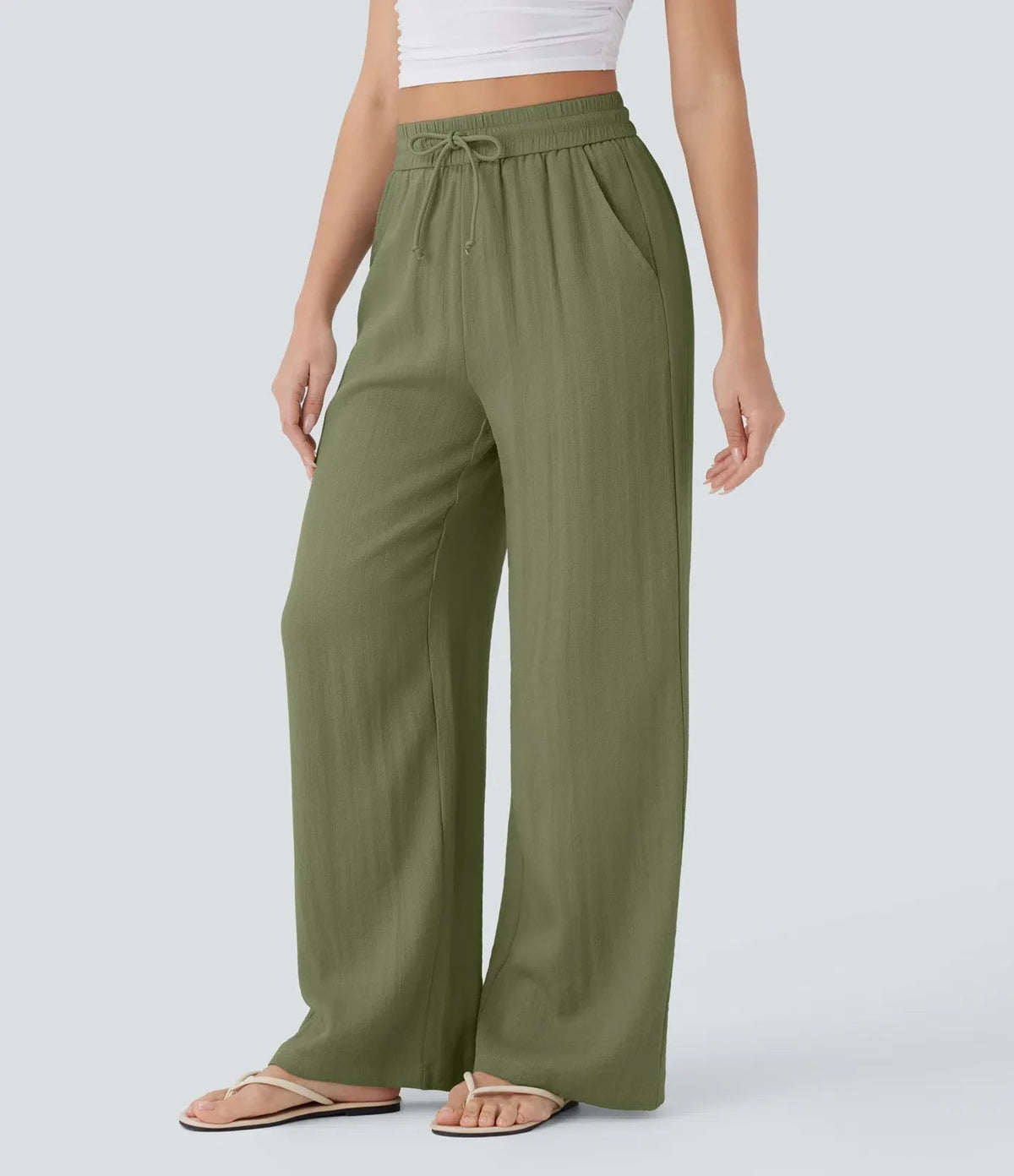 Olive green wide-leg trousers with elastic waist and drawstring, full-length fit.
