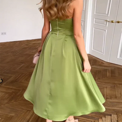 Abito midi verde con schiena a vista, bustier aderente e gonna a ruota svasata