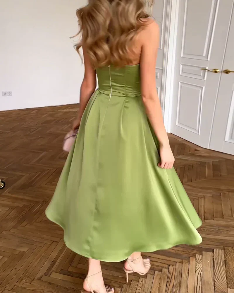 Abito midi verde con schiena a vista, bustier aderente e gonna a ruota svasata