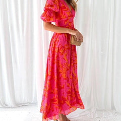 Abito maxi aderente in vita con scollo a V e maniche a sbuffo; fantasia rosa-arancio