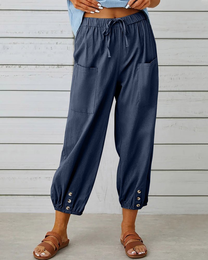 Navy blue relaxed-fit trousers with elastic waist, drawstring, side pockets, button cuff hem.