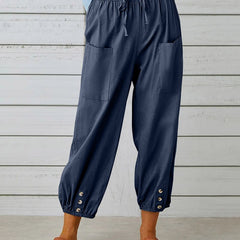 Navy high-waist drawstring jogger trousers with side pockets and snap cuffs.