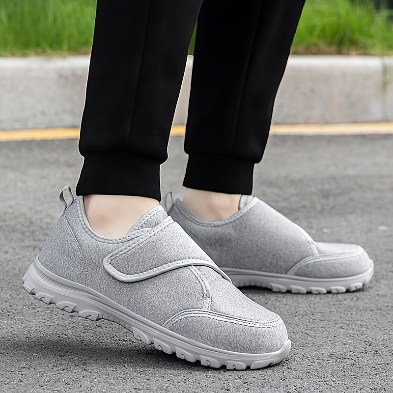 Scarpe ortopediche grigie con cinturino a strappo e suola spessa, indossate