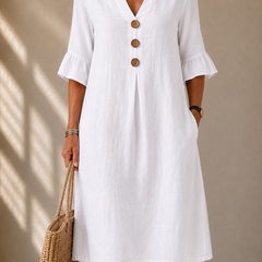 White button-front dress with V neckline and three-quarter puff sleeves