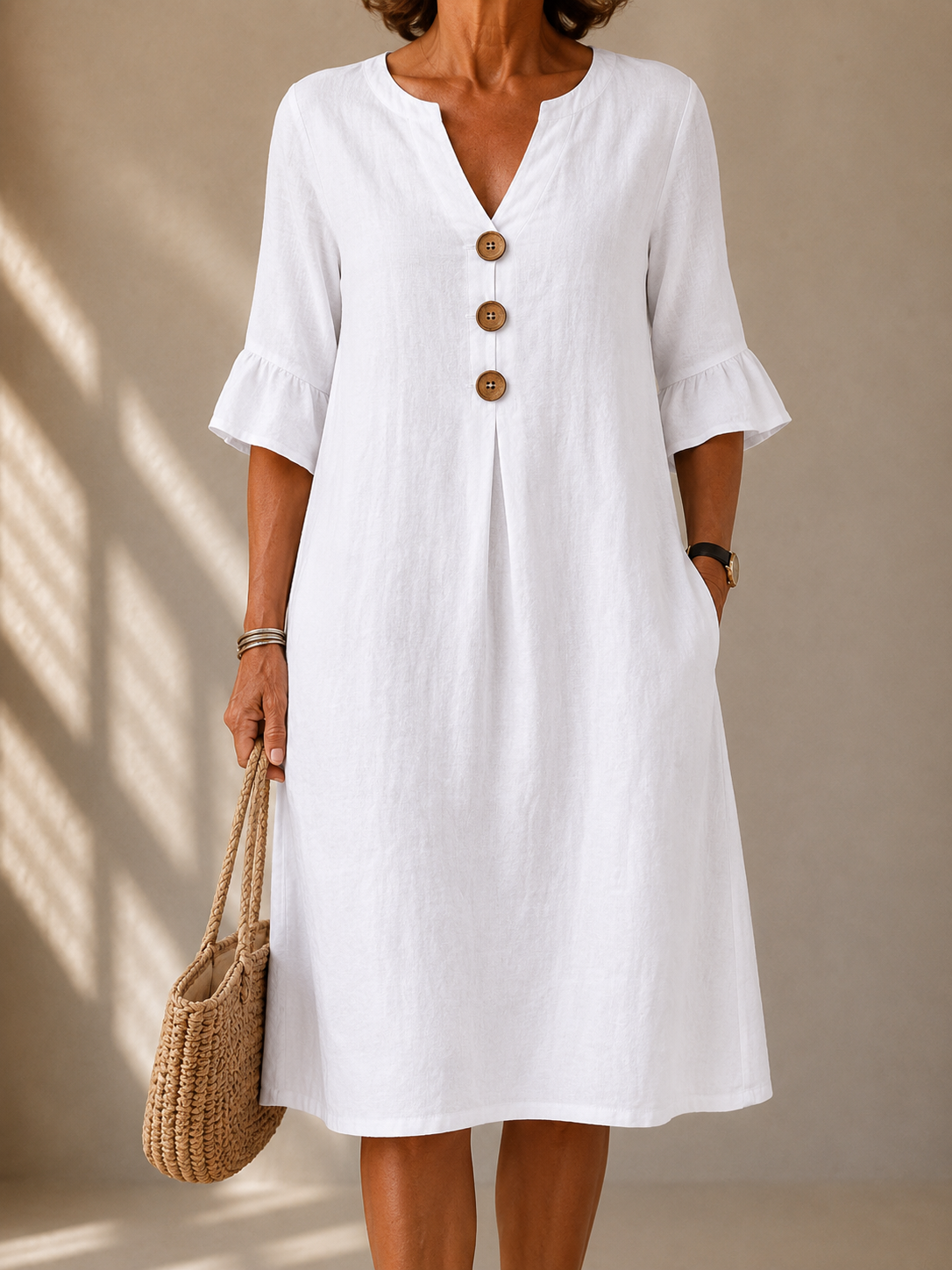 White button-front dress with V neckline and three-quarter puff sleeves