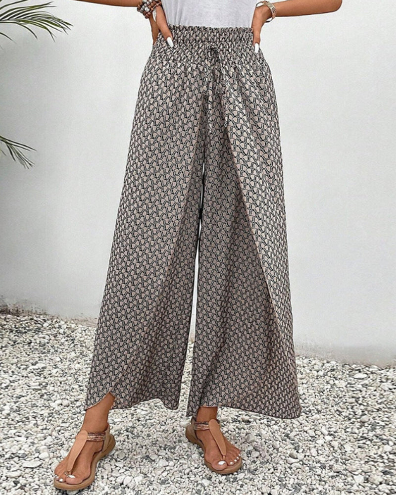 Grey wide-leg trousers with shirred waistband, flowing drape, allover micro pattern.