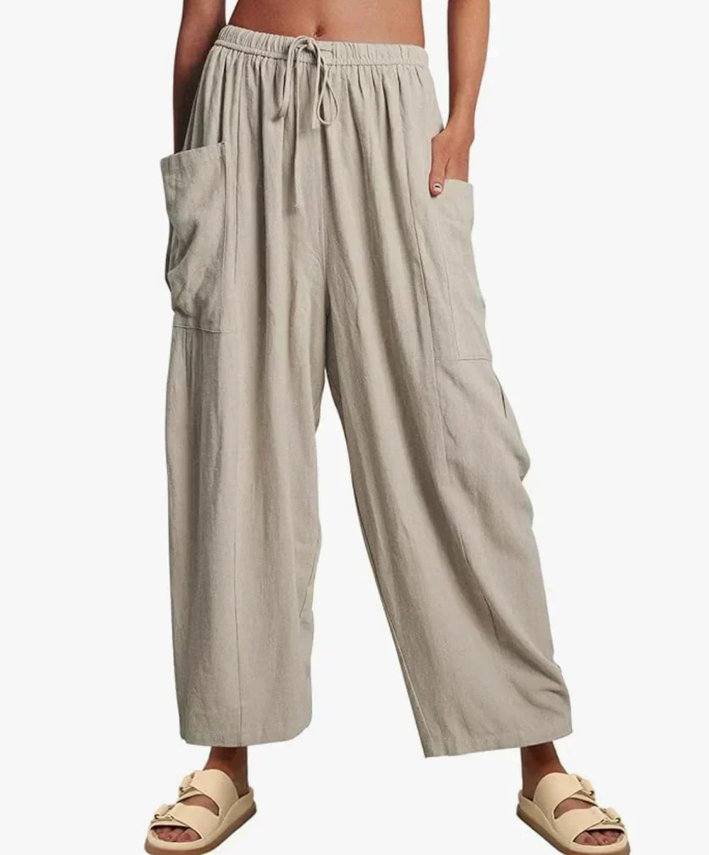 Light gray wide-leg trousers with elastic waist and drawstring, side cargo pockets.