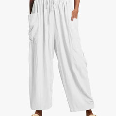 White wide-leg trousers with elastic waist and drawstring, side cargo pockets.
