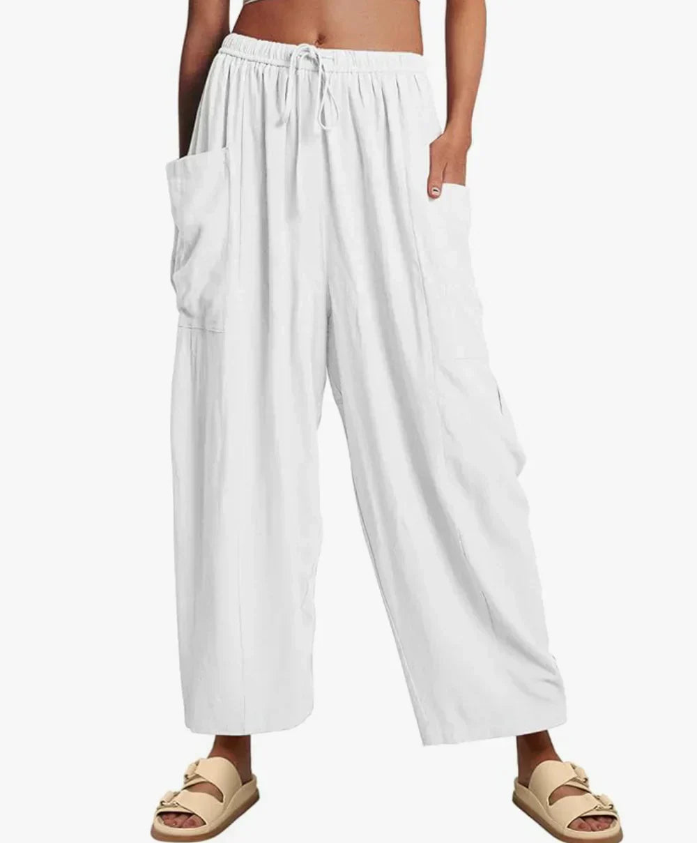 White wide-leg trousers with elastic waist and drawstring, side cargo pockets.