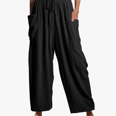 Black wide-leg trousers with elastic waist and drawstring, side cargo pockets.