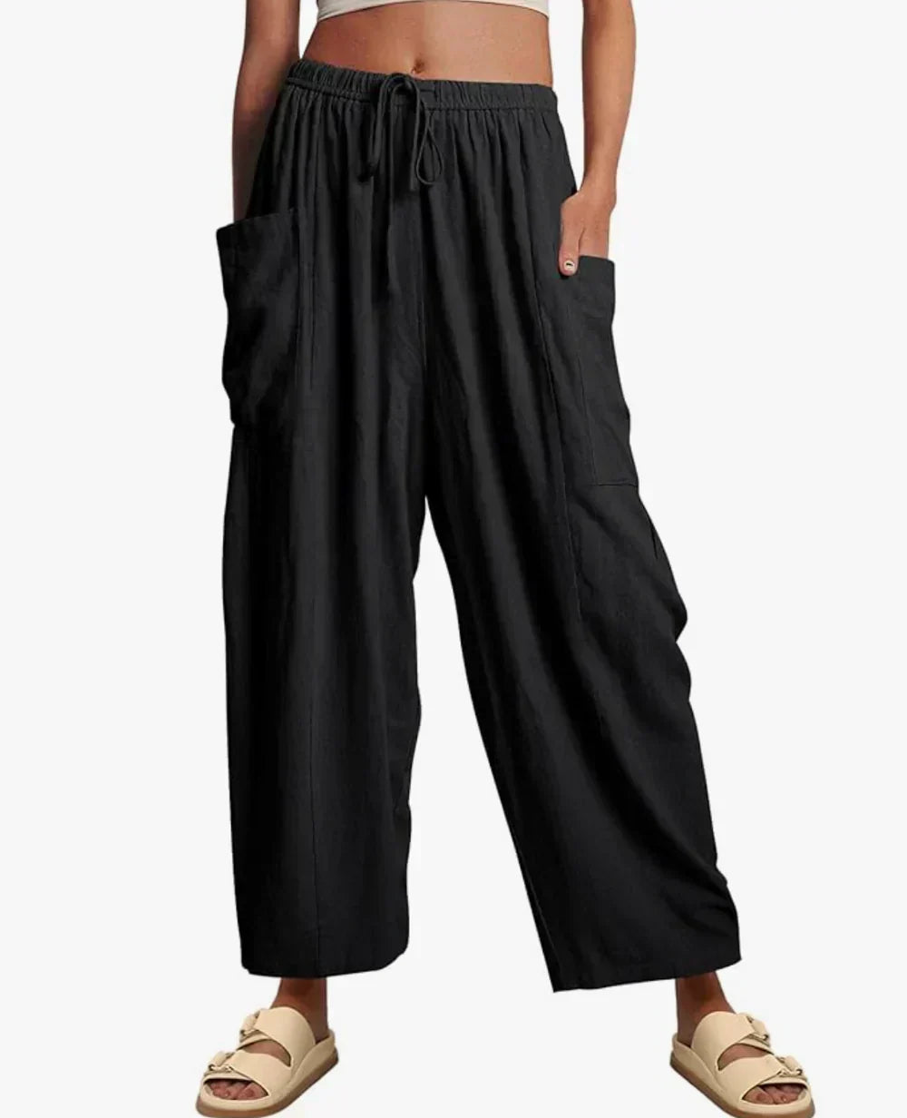 Black wide-leg trousers with elastic waist and drawstring, side cargo pockets.