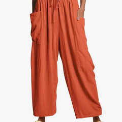 Orange wide-leg trousers with elastic waist and drawstring, side cargo pockets.