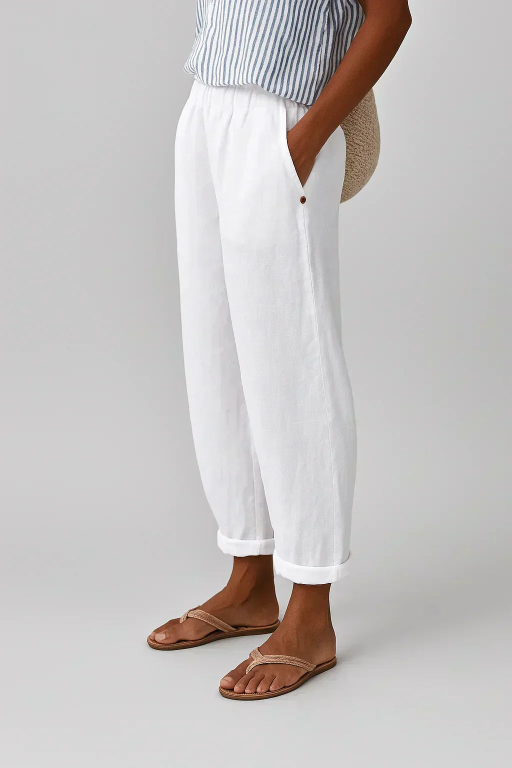 White linen-look cropped trousers with elastic waistband and button cuff hems