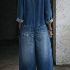 Blue denim overall, off-shoulder neckline, button front, back view with side pockets