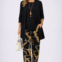 Black three-piece trouser set with long cardigan and gold-chain patterned trousers