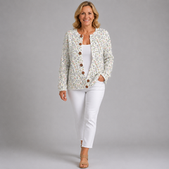 Floral knit cardigan with button-front and long sleeves worn over white pants