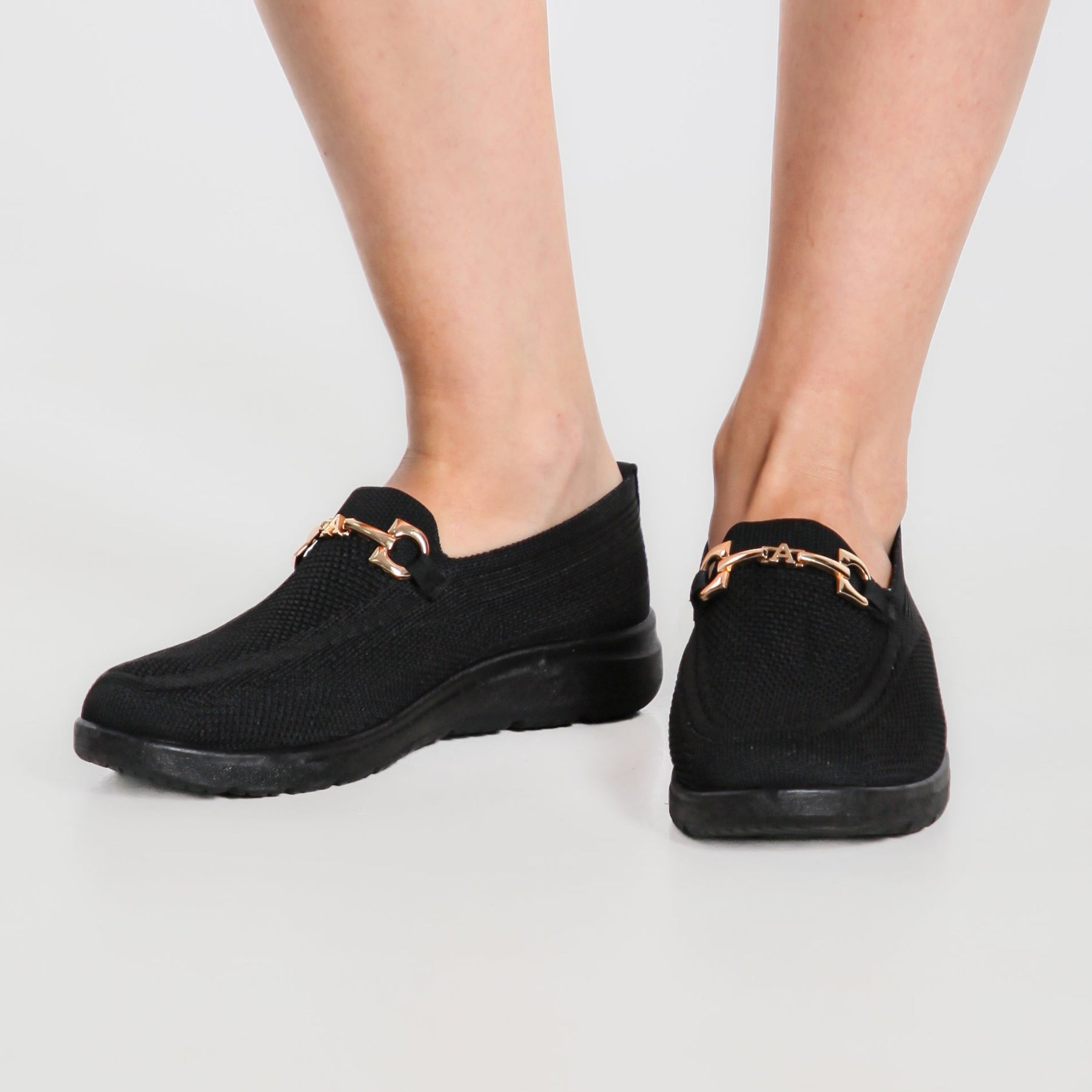 Mocassino comfort nero con suola bianca, punta arrotondata e fibbia dorata