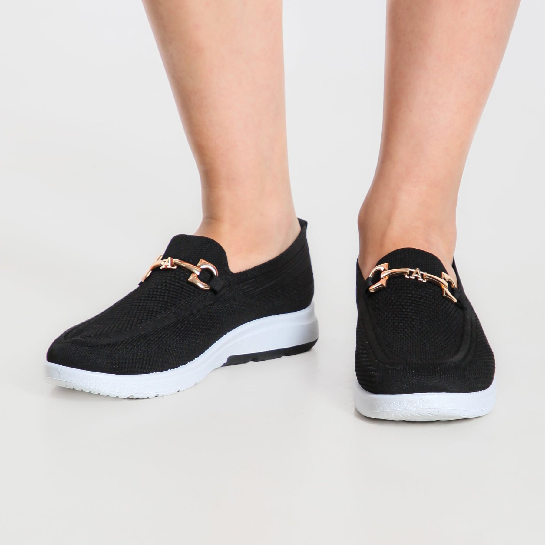 Mocassino comfort nero con suola bianca, fibbia metallica dorata sulla tomaia