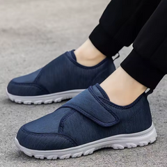 Scarpe ortopediche blu in tessuto con cinturino a velcro e suola bianca, vista laterale