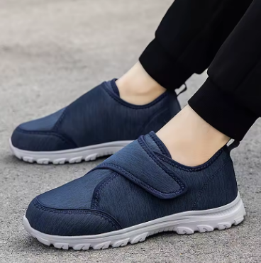 Scarpe ortopediche blu in tessuto con cinturino a velcro e suola bianca, vista laterale