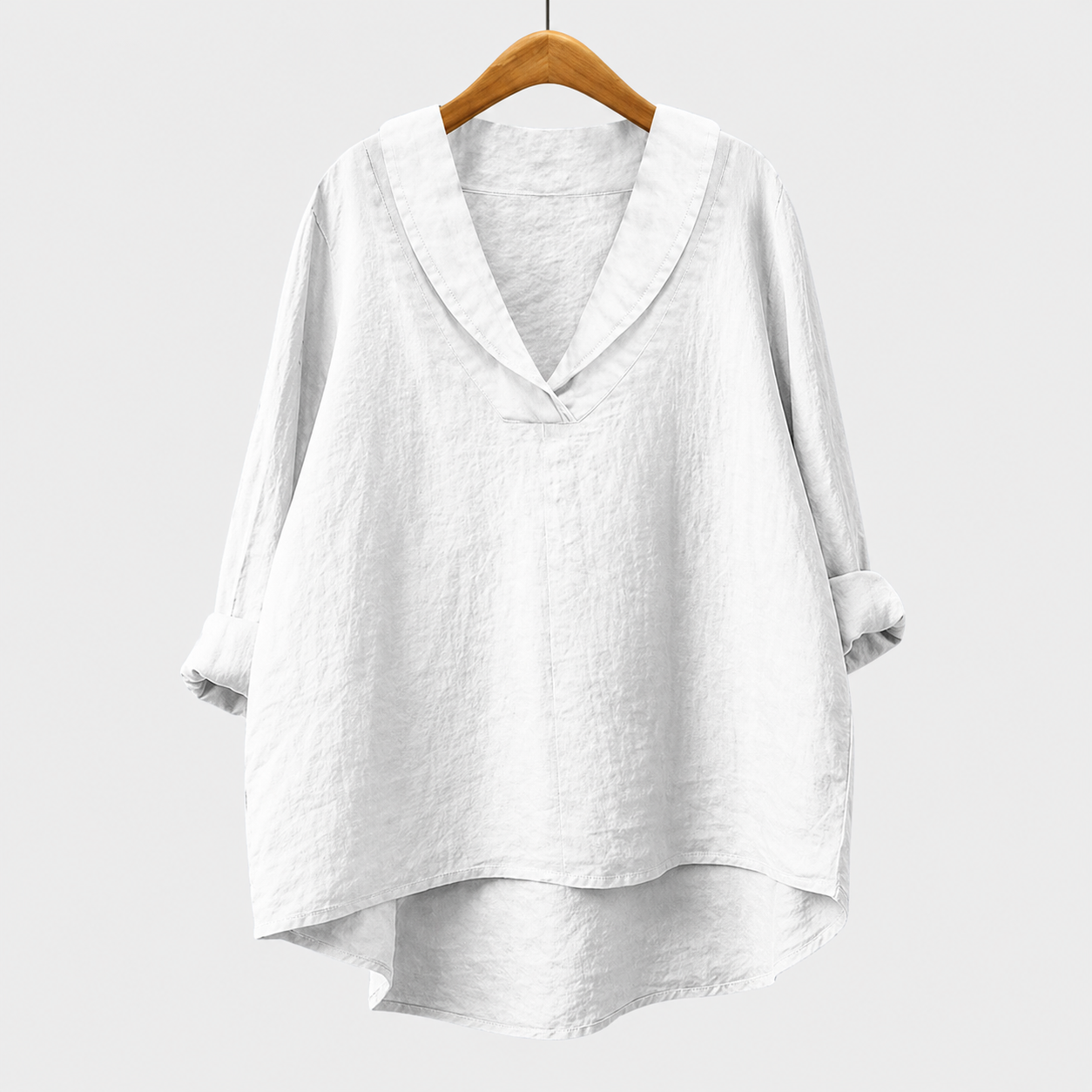 Blusa estiva bianca in tessuto leggero, scollo a V, maniche ampie, orlo asimmetrico.