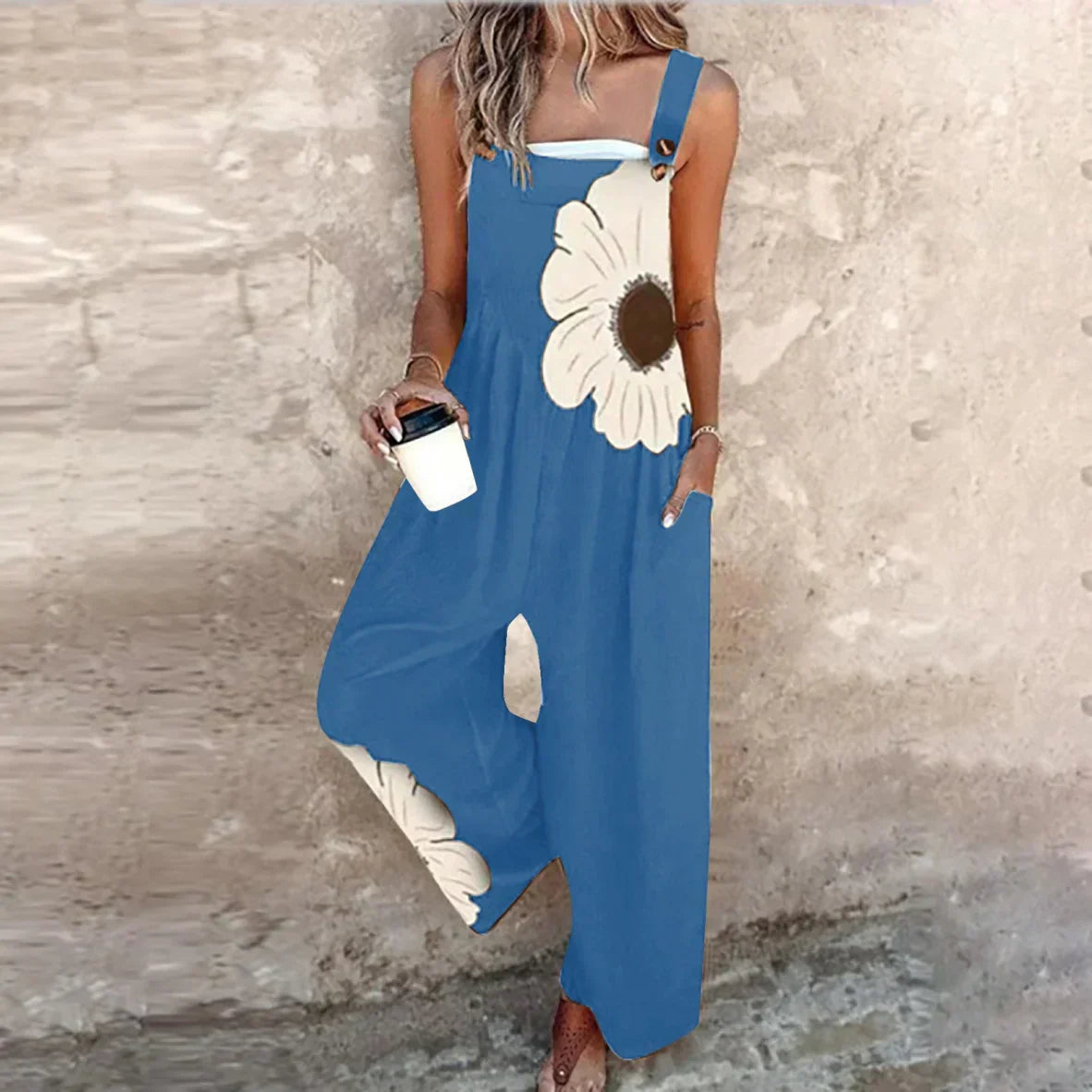 Blue sleeveless floral printed overalls with wide legs and cream flower accent