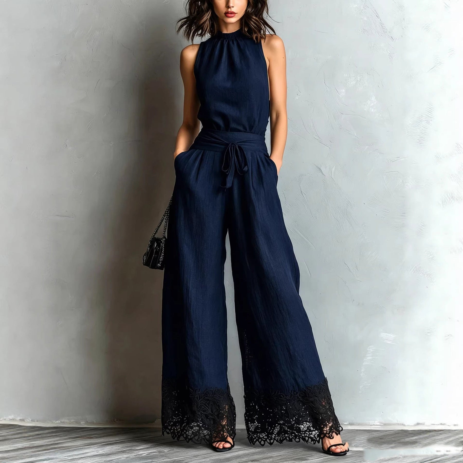 Navy blue halter-neck lace-trim wide-leg jumpsuit with waist belt tie and black lace cuffs