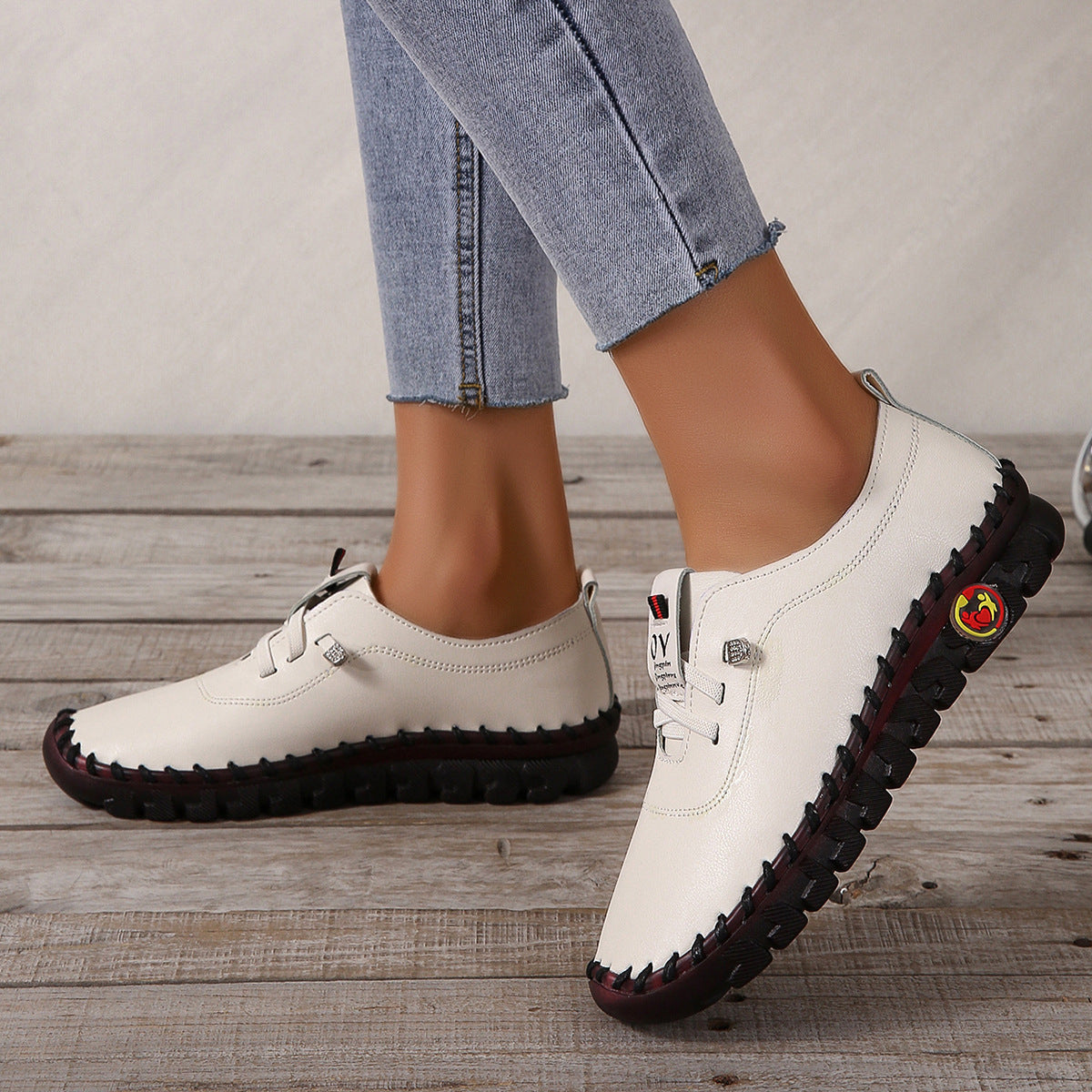 Scarpe casual bianche, dettaglio suola antiscivolo, indossate con jeans