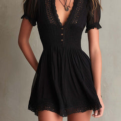 Black V-neck mini dress with smocked waist, crochet lace hem, and short ruffle sleeves.