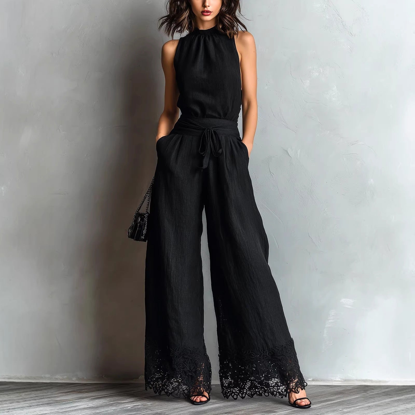 Black halter-neck lace-trim wide-leg jumpsuit with waist belt tie and black lace cuffs