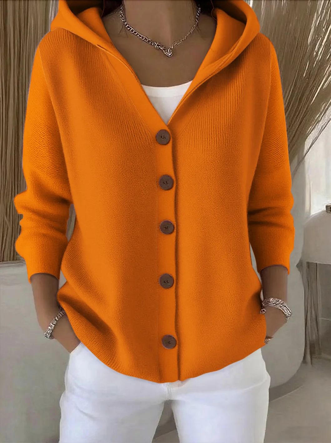 Orange hooded button-up knit cardigan with dark buttons, long sleeves