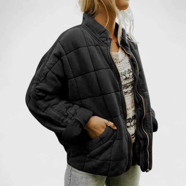Quilted black zip-up jacket with stand collar and side pockets, long sleeves