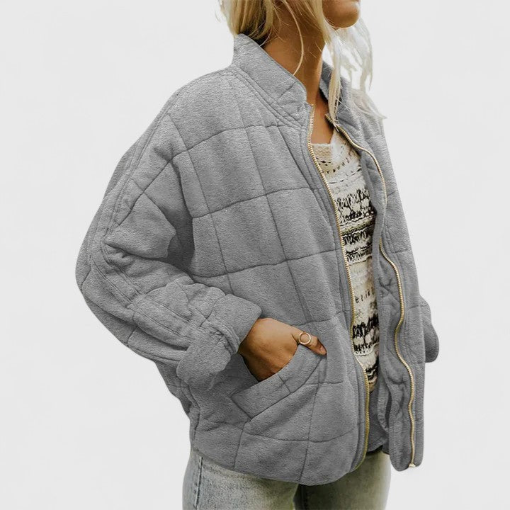 Quilted grey zip-up jacket with stand collar and side pockets, long sleeves