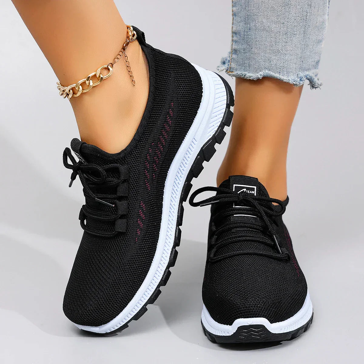 Sneakers nere traspiranti con lacci e suola bianca, vista frontale