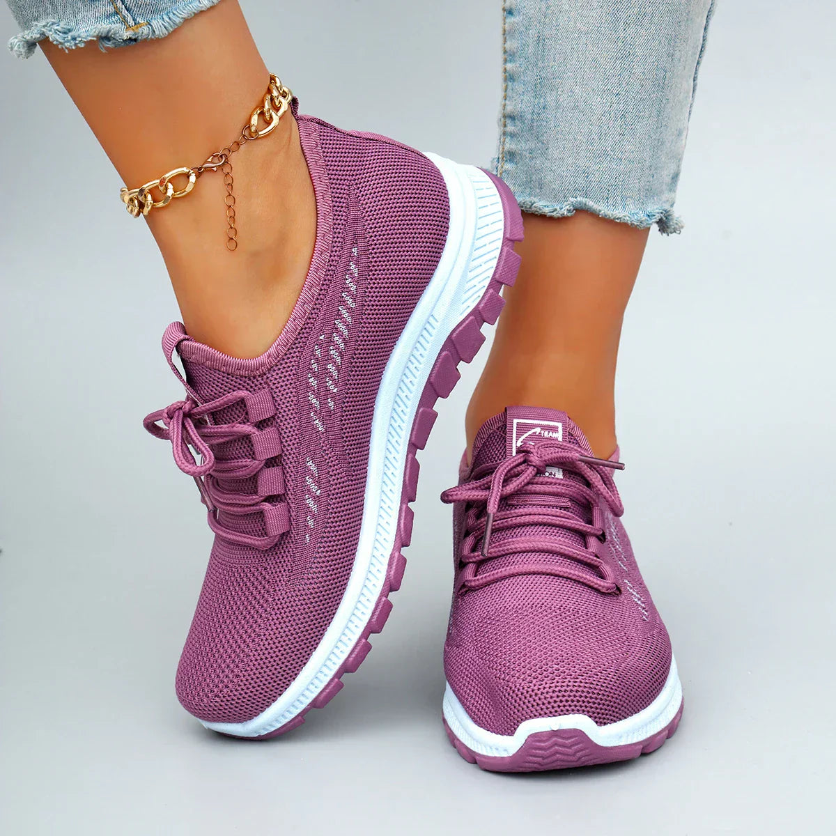 Sneakers rosa traspiranti con lacci, suola bianca e fondo zigrinato