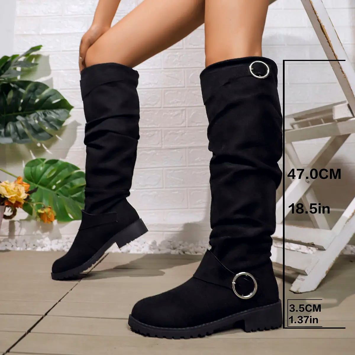 Knee-high black boots with round buckle rings and chunky lug sole