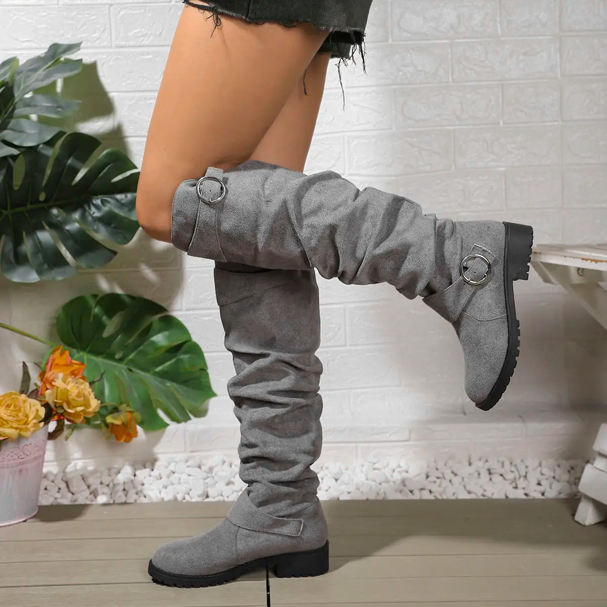 Knee-high grey suede boots with buckle rings and chunky lug sole