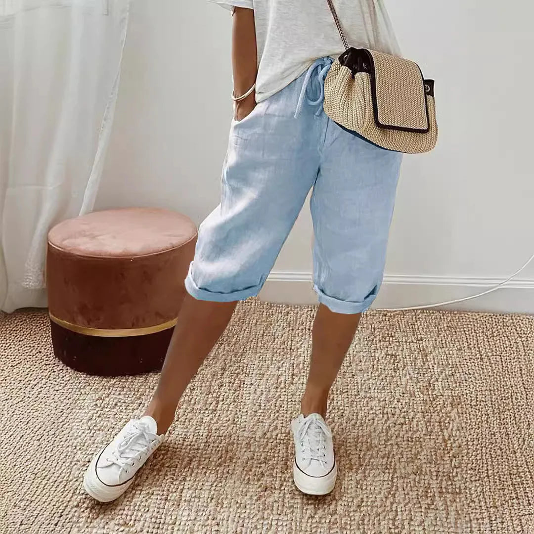 Lightweight summer shorts in light blue, rolled hem, drawstring waist, side pockets.