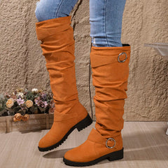 Knee-high orange suede boots with round buckle ring straps and lug sole