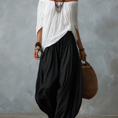 Completo con top bardot bianco drappeggiato e pantaloni ampi neri