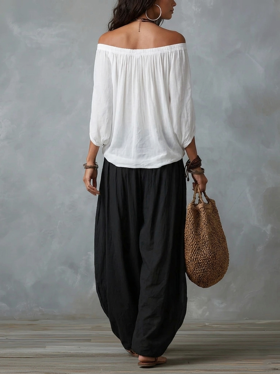 Completo con top bardot bianco e pantaloni ampi neri, vista posteriore