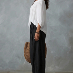 Completo con top spalle scoperte bianco e pantaloni ampi neri, lato