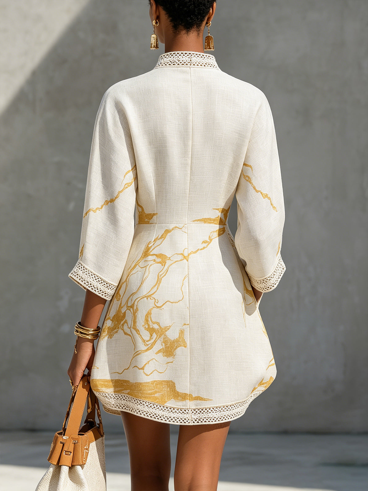 Back of ivory midi dress with V-shaped lace detail and gold abstract print