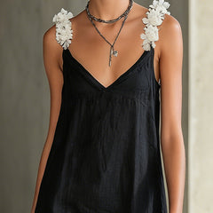 Black V-neck midi dress with layered floral shoulder appliques and thin straps.