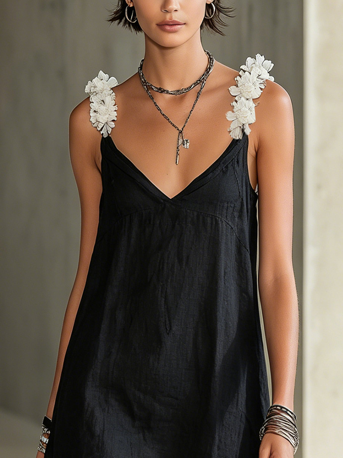 Black V-neck midi dress with layered floral shoulder appliques and thin straps.