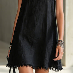 Black midi dress hem with fringe trim and V-neck bodice detail.