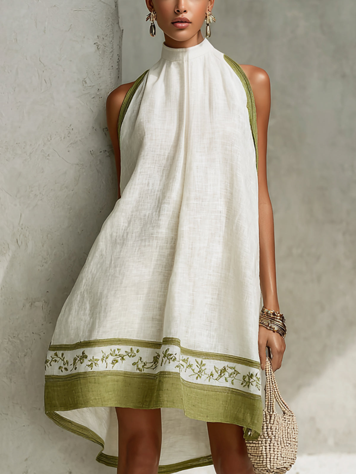 White halter midi dress with high neckline and green floral hem border